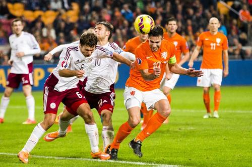 El jugador holand&eacute;s, Robin van Persie, compite con Vladislavs Gabovs de Letonia y Valerijs Sabala, este domingo en el partido de clasificaci&oacute;na la Euro 2016. (Foto: AFP)