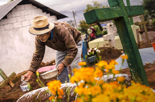 Un vecino de Sumpango decorando una tumba por la mañana