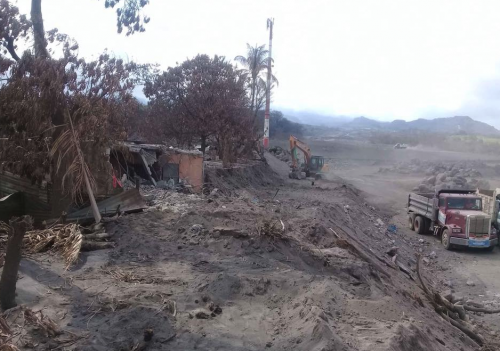 Los camiones trabajan al lado de la comunidad arrasada. (Foto: Facebook)