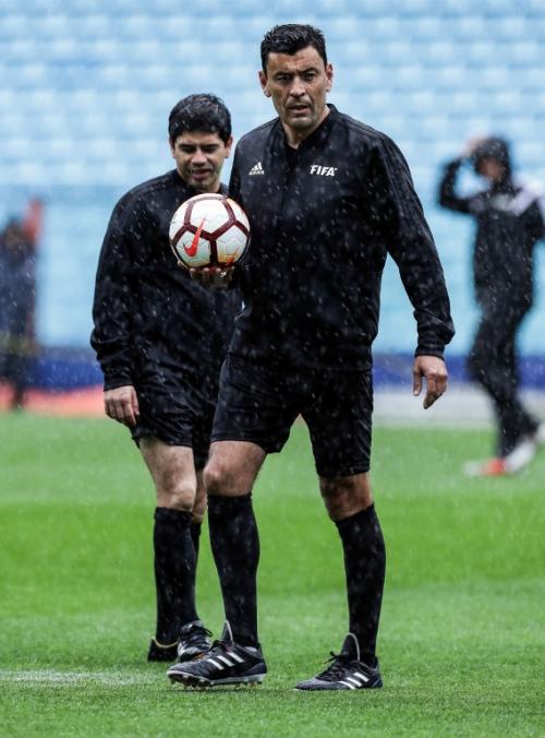El referí chileno saltó a la cancha para verificar el estadio del campo de la Bombonera. (Foto: AFP)