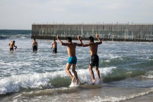 Un grupo de migrantes se ba&ntilde;a en la playa de Tijuana, en la frontera con EE.UU. (Foto: AFP)