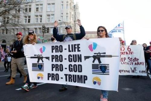 Cartel con las consignas "provida, proarmas, pro-Dios, pro-Trump" en una marcha de simpatizantes del presidente Donald Trump, en la capital estadounidense el 12 de diciembre de 2020. (Foto: AFP) 
