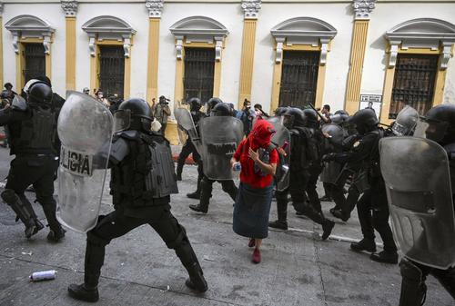 En esta imagen, la mujer se quedó atrapada entre la columna policial que buscaba ejecutar capturas. (Foto: Johan Ordóñez / AFP)