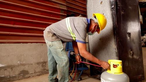 Trabajador extrae gases refrigerantes. (Foto: BBC)