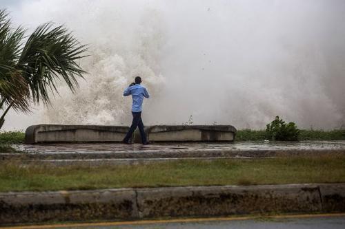 en la imagen, un hombre se arriesga a a tomar una fotografía de las fuertes olas causadas por la tormenta. (Foto: AFP)