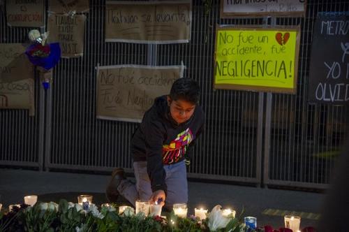 Familiares dejan flores y candelas en el lugar del accidente donde perdieron a sus seres queridos. (Foto: AFP)