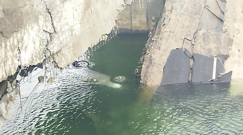 El vehículo del soldado ucraniano quedó bajo el agua tras la explosión que dejó inestable el puente. 
