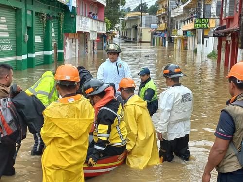 Bomberos trasladan a personas en lanchas en Cob&aacute;n,  Alta Verapaz. (Foto: Bomberos Voluntarios)