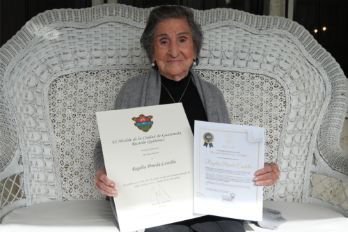 Doña Rogelia Pineda muestra con orgullo los dos reconocimientos municipales obtenidos por llegar a cien años de edad. (Foto: Wilder López/Soy502)