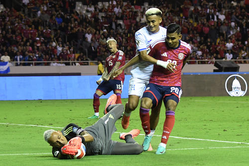 Keylor Navas y Haxzel Quiros se combinan para contener a Andy Najar. (Foto: AFP) 