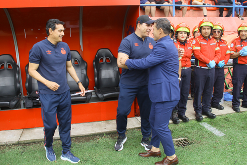 El argentino Sebastián Bini se acerca al banquillo rojo para saludar a Dwight Pezzarossi y Mario Acevedo. (Foto: Eddy Recinos / Nuestro Diario)