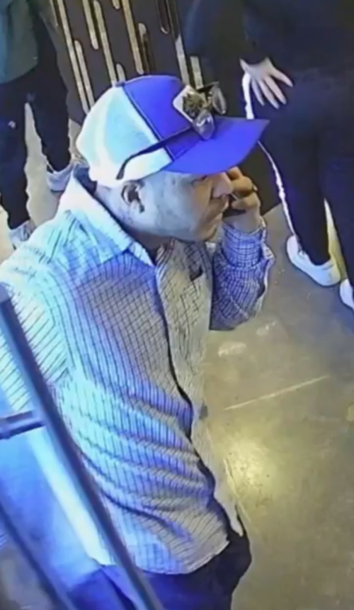 El hombre aparenta hacer una llamada para pasar desapercibido al ingresar a un sal&oacute;n de belleza.
