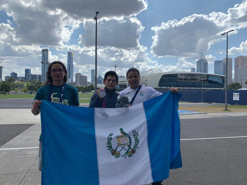 La bandera de Guatemala onde&oacute; en Melbourne, Australia, luego del segundo lugar de Vega en la Copa del Mundo. En la imagen, junto a Mario Pic&oacute;n (juez de gimnasia guatemalteco) y Rodman Murga (entrenador). (Foto: Archivo)