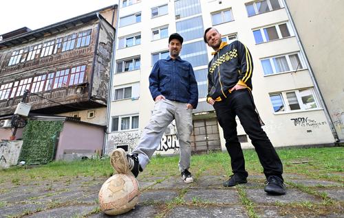 Brano Jakubovic (izquierda) y Vedran Mujagic, posan con una pelota en el patio trasero de un edificio de apartamentos.