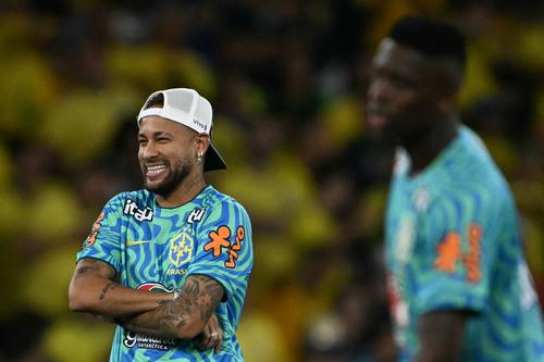 Neymar r&iacute;e con sus compa&ntilde;eros mientras algunos calientan previo a un amistoso.