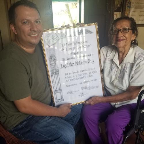 Luz Pilar Natareno Cruz recibiendo el diploma de su homenaje de la FILMA 2024. (Foto: FB/Manfred Morales)