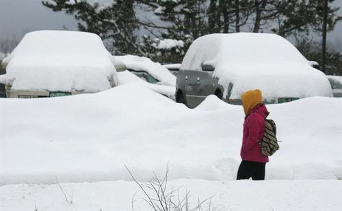 Un estudiante pasa delante de unos coches cubiertos de nieve en el campus de la universidad Lyndon en Lyndonville, Estados Unidos. (Foto: EFE) 