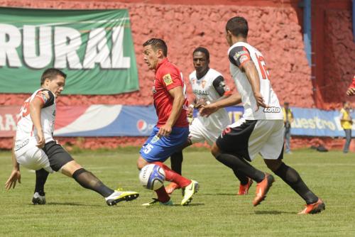 Mario Rodr&iacute;guez, quien anot&oacute; el primer gol del encuentro, trata de eludir la marca de Luis Rodr&iacute;guez durante en una de las acciones del juego en el estadio Manuel Felipe Carrera