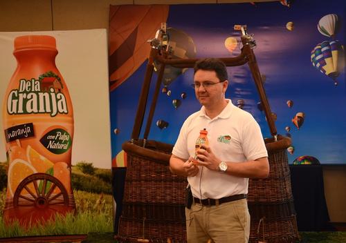 Vinicio &Aacute;vila, gerente de mercadeo de "De la Granja" muestra el nuevo envase, que adem&aacute;s contiene el ticket para participar en la promoci&oacute;n. (Foto: Selene Mej&iacute;a/Soy502) 