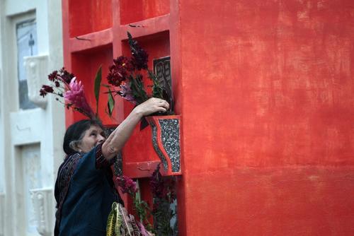 Los familiares limpian y adornan las tumbas de los muertos para celebrar un gran día. (Esteban Biba/EFE) 