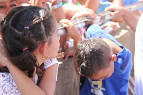 Una ni&ntilde;a mira como se refresca su amigo por las altas temperaturas. (Foto: Roberto Caubilla/Soy502)