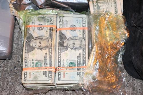 Billetes de 20 d&oacute;lares iban en un malet&iacute;n que transportaban los individuos.  (Foto: PNC)