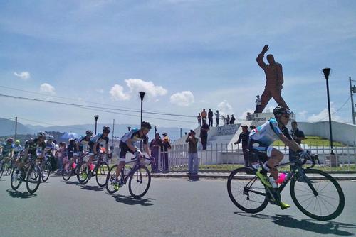 Los ciclistas pasan frente al monumento al migrante en Salcaj&aacute;, Quetzaltenango