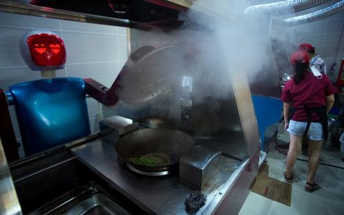 En este restaurante, los robots no solo sirven la comida, también la cocinan (Foto: AFP)