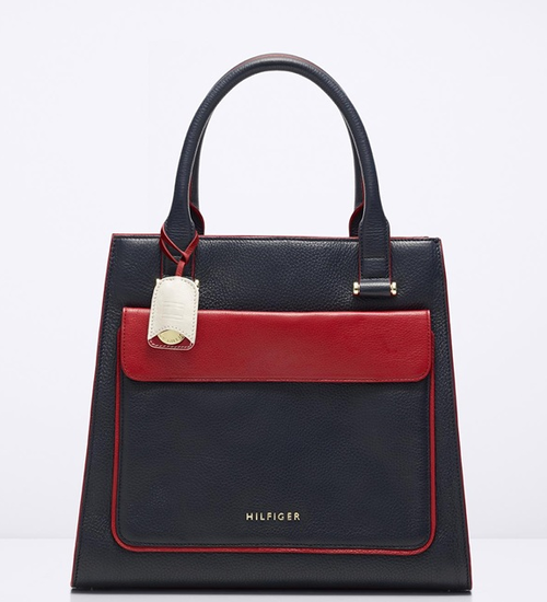 El bolso es de tama&ntilde;o mediano, color azul marino y con detalles en rojo cereza.