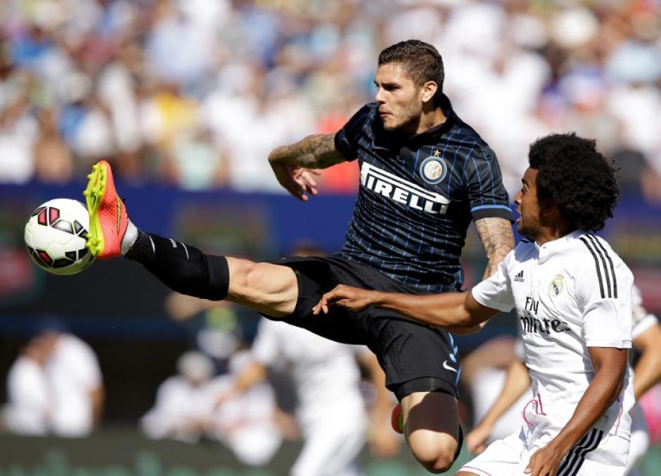 Mauro Icardi salta para tratar de controlar el bal&oacute;n frente a Derik Osede, del &nbsp;Real Madrid, en la Champions Cup Internacional 2014 que se juega en el California Memorial Stadium. (Foto: AFP)