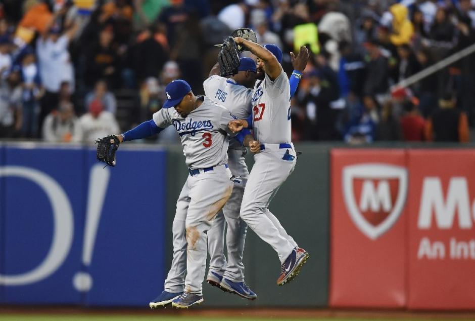 Yasiel Puig, Matt Kemb y Car Crawford celebran el triunfo de los Dodgers ante los Gigantes. (Foto: AFP)