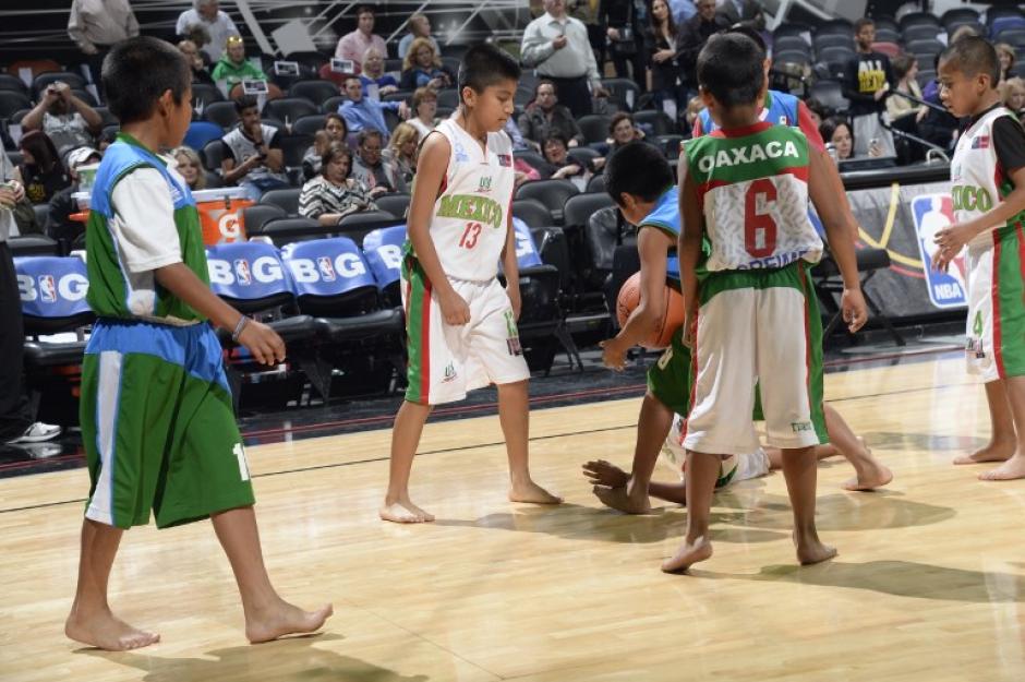 Los ni&ntilde;os "Triquis", originarios de Oaxaca, M&eacute;xico, y famosos por jugar baloncesto descalzos, fueron invitados por segunda vez a la duela de los Spurs de San Antonio y jugaron entre s&iacute; al medio tiempo del juego entre los Spurs y los Heat. (Foto: AFP)