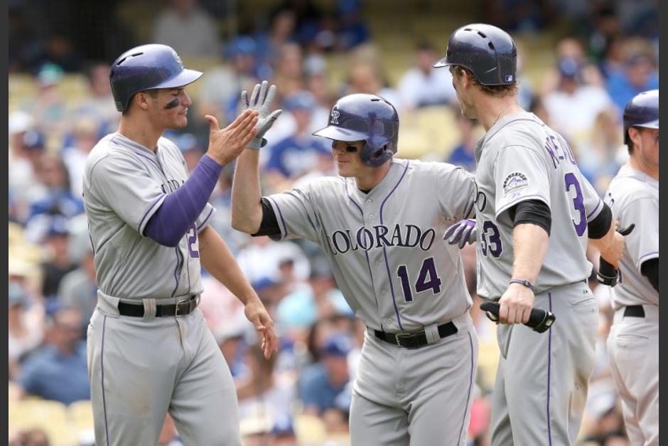 Josh Rutledge (14) y Nolan Arenado (28) celebran la victoria ante los Dodgers. (Foto: AFP)