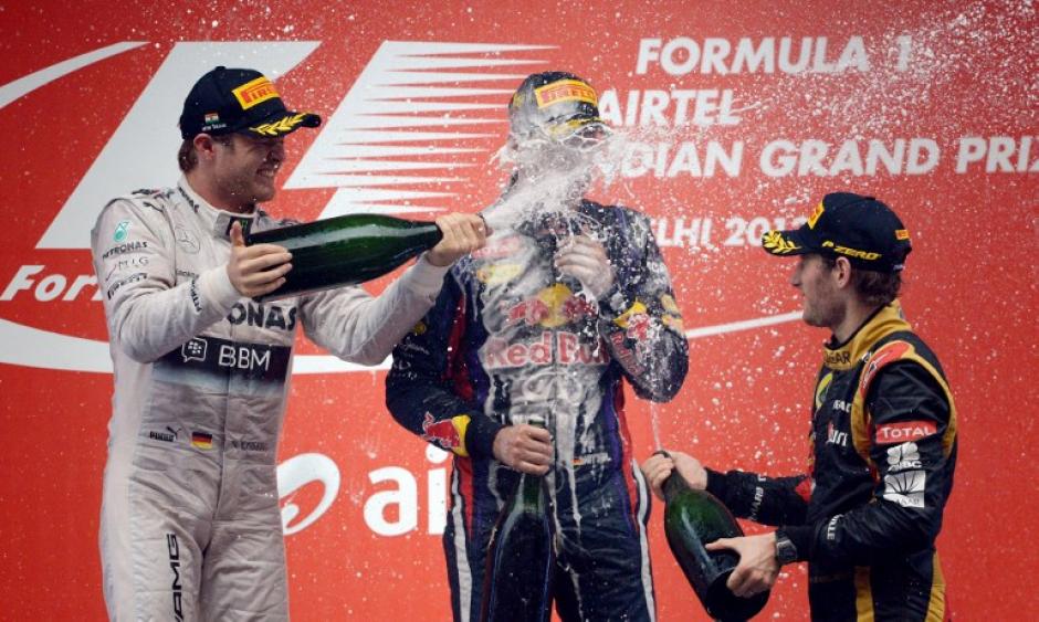 Sebastian Vettel es ba&ntilde;ado con champagne, tras ganar el Gran Premio de India y convertise en tetracampe&oacute;n de F1. (AFP)
