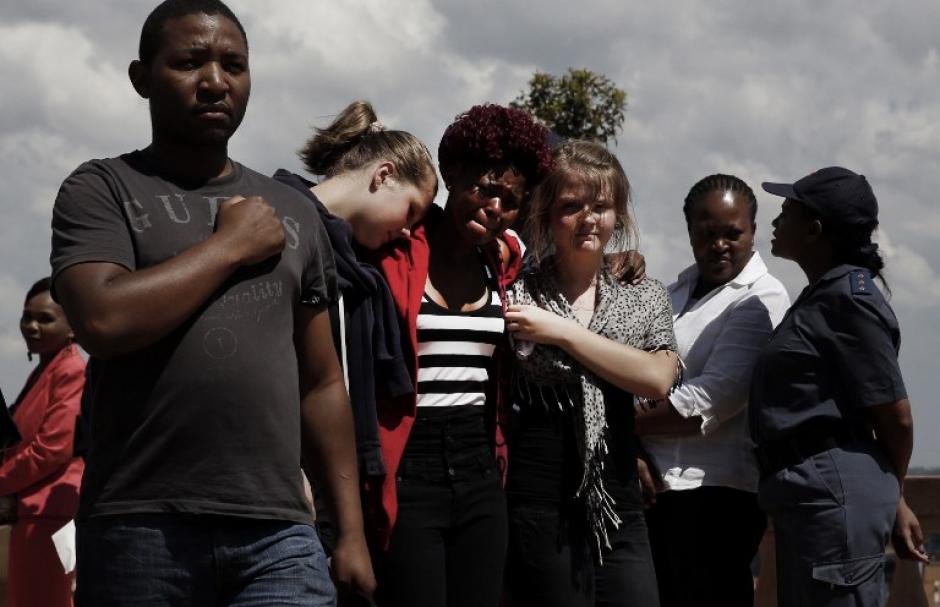 Ciudadanos sudafricanos se consuelan entre s&iacute; ante las &uacute;ltimas horas de despedida de su l&iacute;der Nelson Mandela. Foto AFP