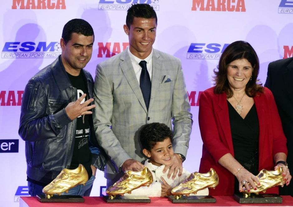 Cristiano Ronaldo, su hermano, su madre y su hijo frente a sus cuatro trofeos de la Bota de Oro. (Foto: AFP)