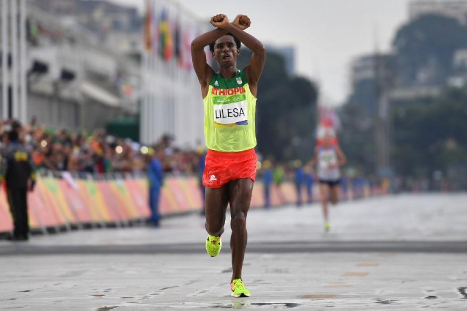 Con este gesto entr&oacute; Feyisa Lilesa a la meta. (Foto: AFP)