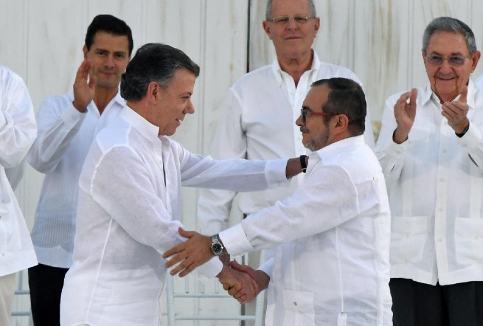 Luego de que se firmaran los acuerdos de paz, Santos y Londo&ntilde;o se dan la mano. (Foto: AFP)