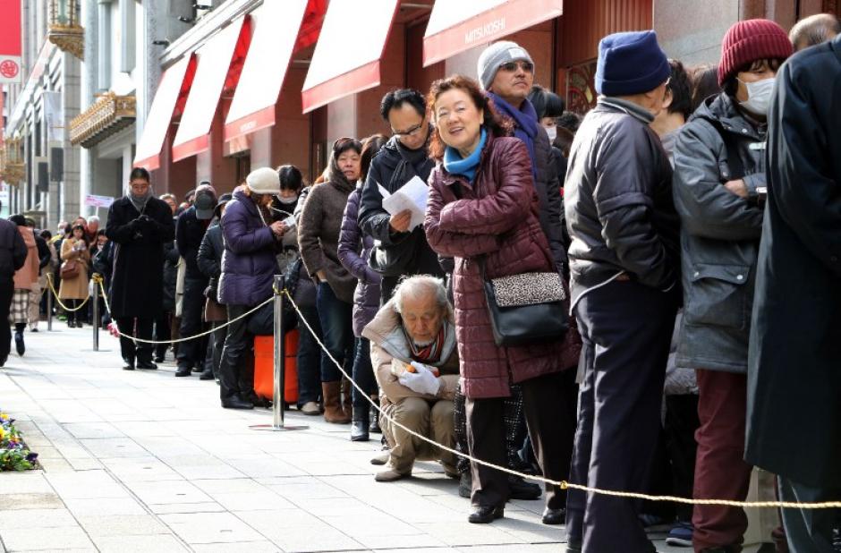 Compradores japoneses hacen cola fuera de una tienda por departamentos, ya que esperar para entrar con la esperanza de recoger "bolsas de la suerte" que contienen art&iacute;culos por valor de tres veces su precio, durante una venta para celebrar un nuevo a&ntilde;o de negocios. Foto: AFP/YOSHIKAZU TSUNO)