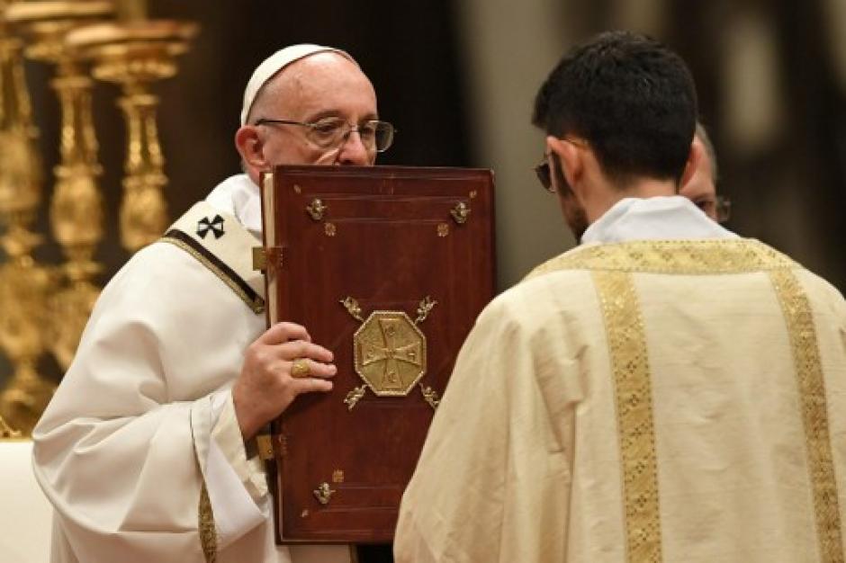El papa Francisco sostiene el libro de los Evangelios durante la misa en la v&iacute;spera de la Navidad, que marca el nacimiento de Jesucristo. (Foto: AFP)