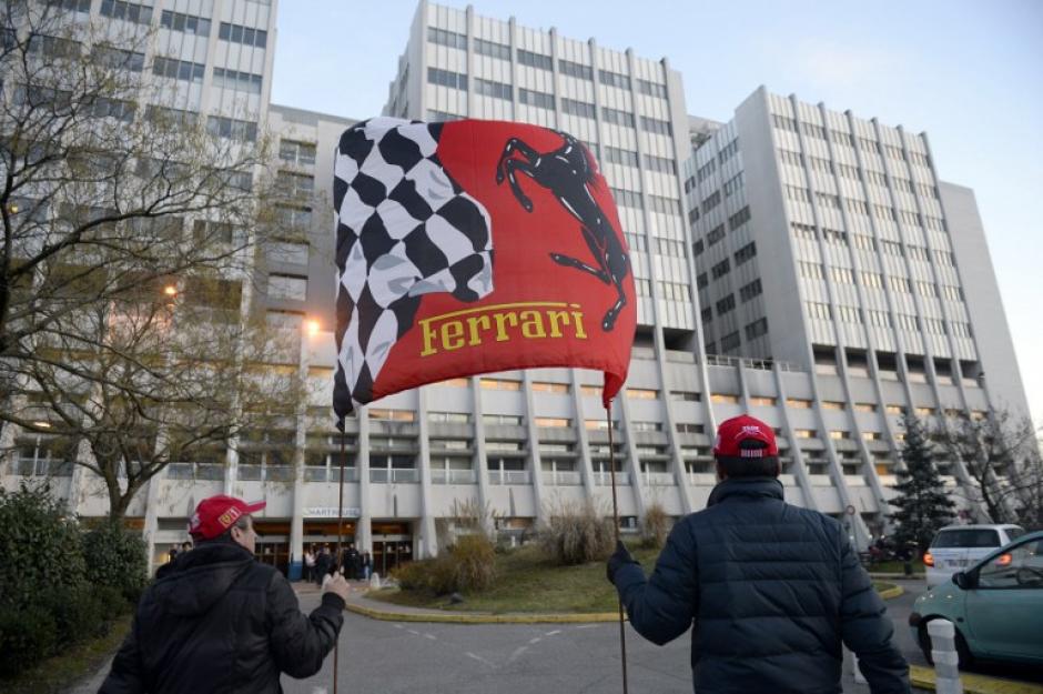 Unos aficionados sostienen la bandera de Ferrari, frente al Centro Hospitalario Universitario de Grenoble, en los Alpes franceses, donde el siete veces campe&oacute;n alem&aacute;n de F&oacute;rmula 1, Michael Schumacher se encuentra en estado cr&iacute;tico despu&eacute;s de un accidente de esqu&iacute; fuera de pista. (AFP)