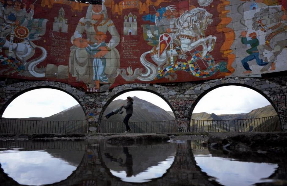 Madre e hija juegan a la orilla de una poza, rodeada de murales que narran la historia del pueblo de Gudauri, ubicado a unos 120 kil&oacute;metros de la capital de Georgia. (Foto: Kirill Kudryavtsev/AFP)