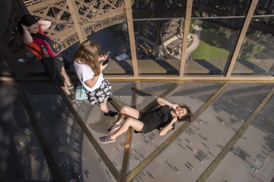Los visitantes toman fotos como se acuestan en el nuevo suelo de cristal en la Torre Eiffel en Par&iacute;s el 3 de octubre de 2014. La Torre Eiffel est&aacute; inaugurando un nuevo piso de vidrio, el 6 de octubre, que se est&aacute; convirtiendo en la atracci&oacute;n de los millones de turistas que acuden a Par&iacute;s, el hito m&aacute;s conocido cada a&ntilde;o. (Foto: AFP/ LIONEL BONAVENTURE)