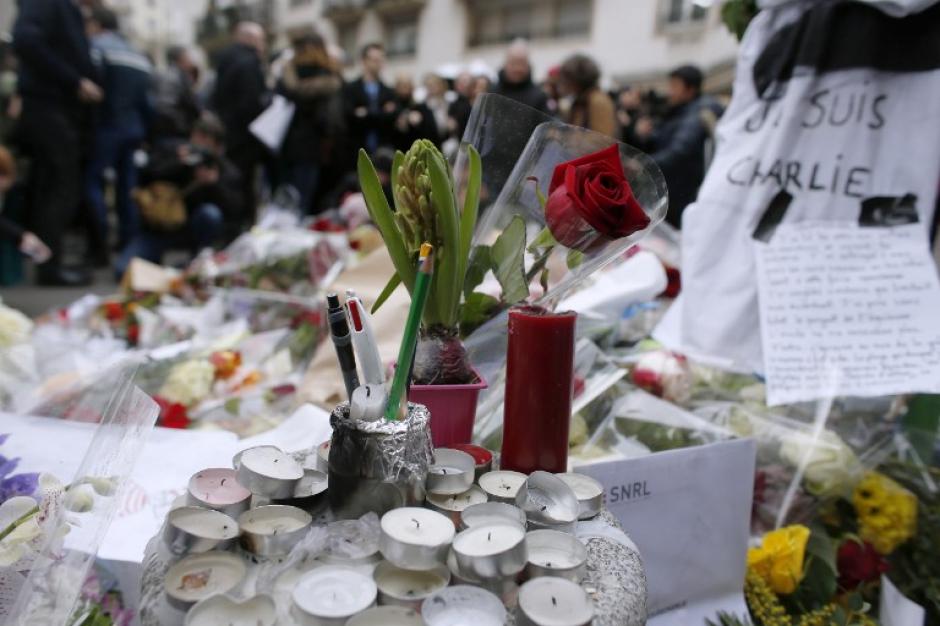Decenas de personas se han acercado a las afueras de las oficinas de Charlie Hebdo para poner arreglos florales y candelas en memoria de las v&iacute;ctimas del atentado que cobr&oacute; la vida de 12 personas a mitad de esta semana en Par&iacute;s, Francia. (Foto: AFP)