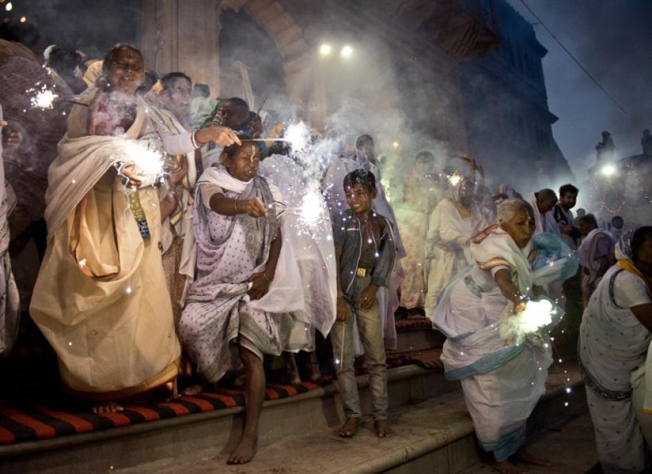 Viudas indias onda bengalas mientras participan en una celebraci&oacute;n para el festival hind&uacute; de Diwali, a orillas del r&iacute;o Yamuna, en la norte&ntilde;a ciudad de Vrindavan el 21 de octubre de 2014. (Foto: AFP/ROBERTO SCHMIDT)