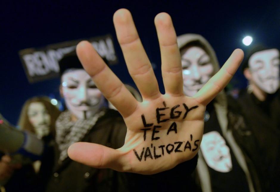 Un manifestante muestra su palma con un texto "S&eacute; el cambio por s&iacute; mismo", ya que cruzan la Szabads&aacute;g (Libertad) Puente durante la llamada manifestaci&oacute;n 'Million M&aacute;scara de marzo' en Budapest el 05 de noviembre 2014 en contra de la corrupci&oacute;n y las desigualdades en la sociedad. (Foto: AFP/ATTILA KISBENEDEK)