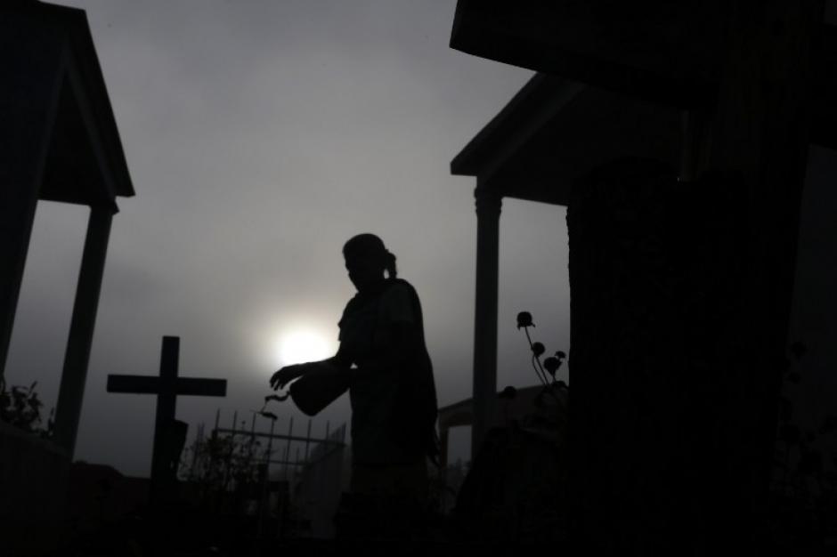 Una mujer limpia una tumba en el cementerio de Tuxtla, estado de Guerrero, M&eacute;xico, durante la celebraci&oacute;n de Todos los Santos el 1 de noviembre de 2015. (Foto: AFP / Pedro PARDO)