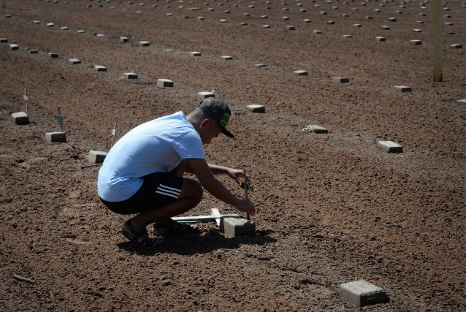 Voluntarios de la organizaci&oacute;n "Angeles del Desierto" colocan cruces en las tumbas de los inmigrantes ilegales no identificados que murieron cruzando la frontera entre Estados Unidos y M&eacute;xico en un cementerio cerca de Holtville, California. (Foto: AFP/&nbsp;MARK RALSTON)