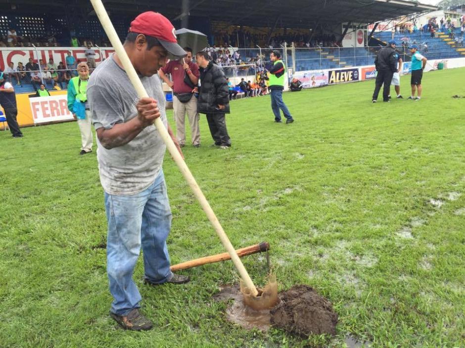 Trabajadors del estadio Carlos Salazar hijo tratan de recuperar la cancha, el juego se realizar&aacute; bajo malas condiciones de la gramilla. (Foto: Nuestro Diario)