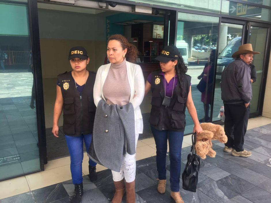 Agentes de la PNC capturan a M&oacute;nica de Jes&uacute;s Rivas Gil en el aeropuerto La Aurora por delito de parricidio y asesinato. (Foto: PNC)